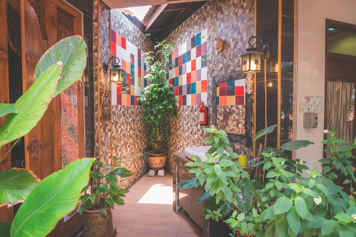 A tiled spa corridor with colourful mosaic squares, hanging lanterns and lush green plants